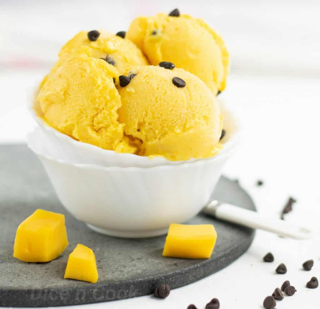 Best mango ice cream with choco chips with step by step pictures and video. This is an ice cream made without ice cream maker. A no churn mango ice cream recipe. #mango #icecream #nochurn #dessert