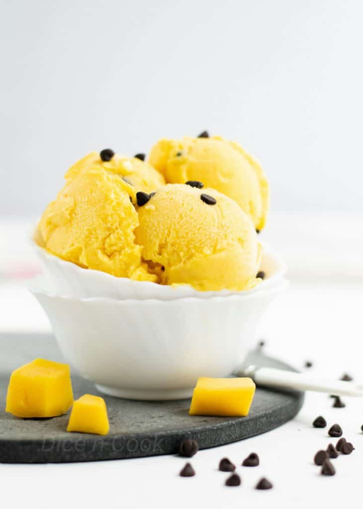 Best mango ice cream with choco chips recipe with step by step pictures and video. This is an ice cream made without ice cream maker. A no churn mango ice cream recipe. #mango #icecream #nochurn #dessert