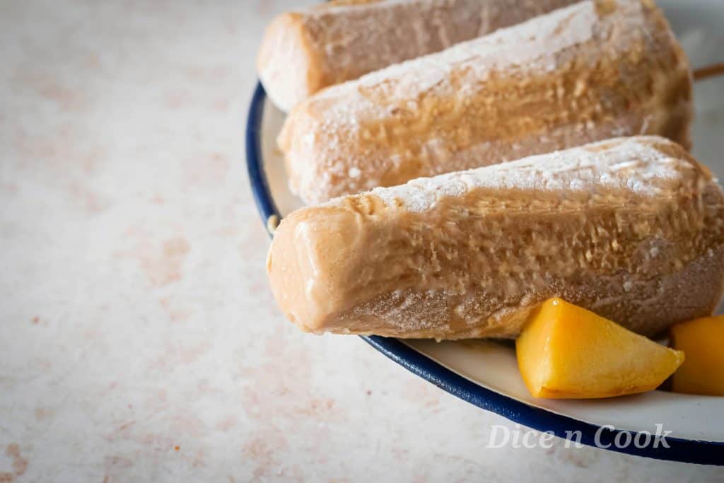 Homemade creamy tropical fruits popsicles is easy recipe with just 5 wholesome ingredients. A healthy dessert to beat the summer heat. This is sugar free recipe with nutty flavour of almond on every bite of popsicle. It just takes 5 minutes to blend them together, pour and freeze. #popsicle #creamy #summer #recipes #icecream