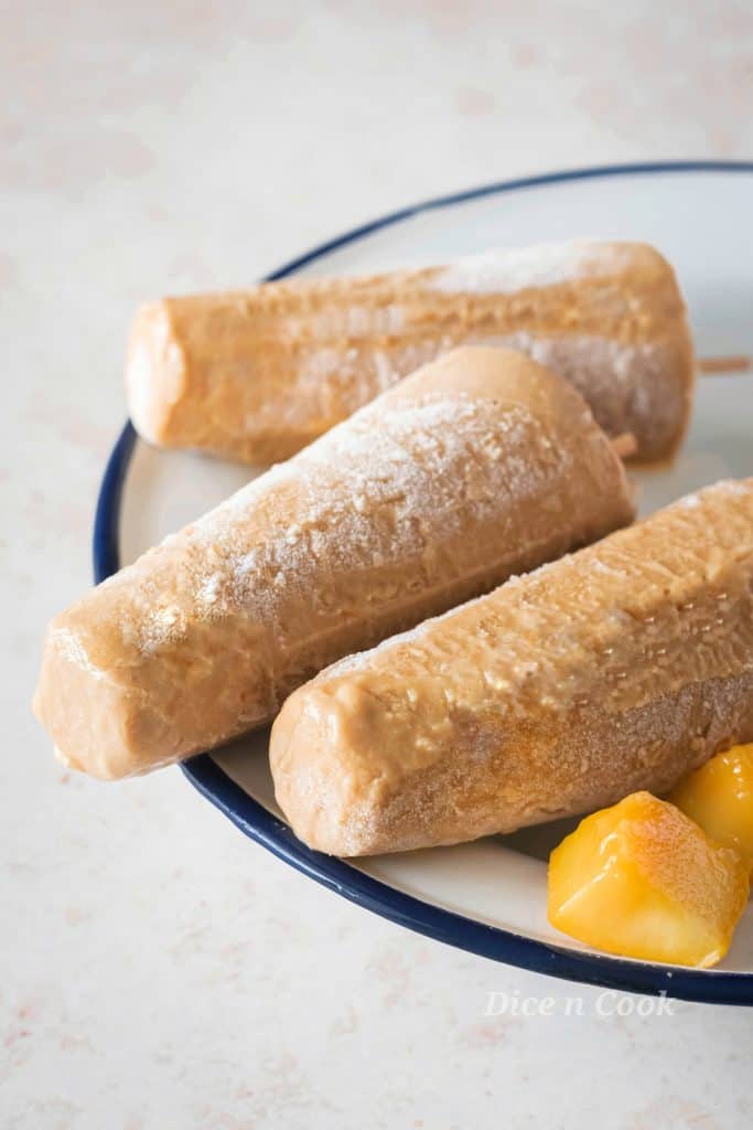 Homemade creamy tropical fruits popsicles is easy recipe with just 6 wholesome ingredients. A healthy dessert to beat the summer heat. This is sugar free recipe with nutty flavour of almond on every bite of popsicle. It just takes 5 minutes to blend them together, pour and freeze. #popsicle #creamy #summer #recipes #icecream