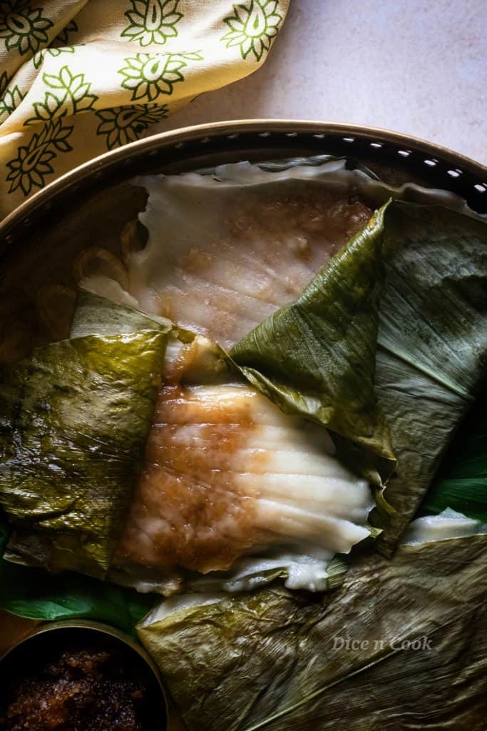 Patholi or kayi genasale are soft rice dumplings steamed in turmeric leaves. Dairy free and glutenfree coastal Karnataka recipe.  These are healthy oil-free, nut free, refined sugar dumplings #glutenfree #vegan #dumplings #steamed #patholi